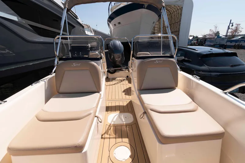 Slide: The Image of 2023 Scout 175 Sportfish boat interior with beige seating and wooden deck. - 10