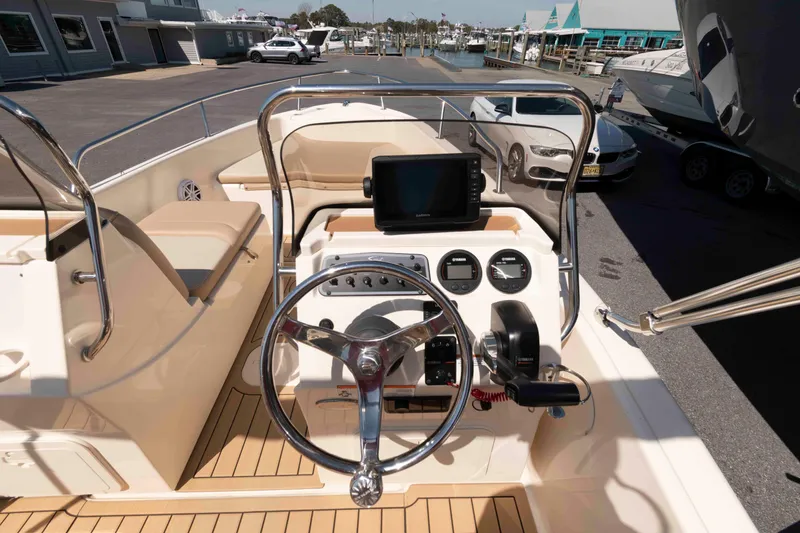 Slide: The Image of 2023 Scout 175 Sportfish boat dashboard with steering wheel and navigation equipment. - 12