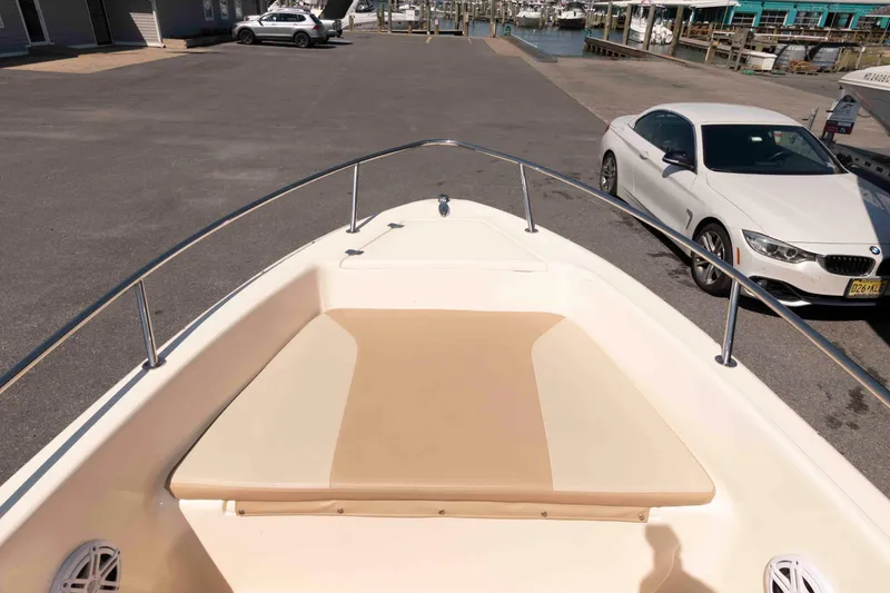 Slide: The Image of 2023 Scout 175 Sportfish boat at marina with parked cars nearby. - 13