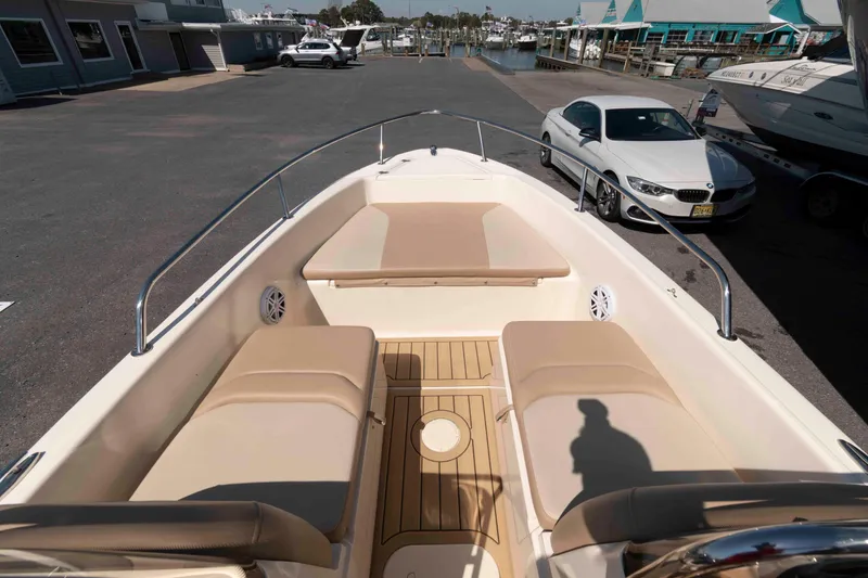 Slide: The Image of 2023 Scout 175 Sportfish boat interior with steering wheel and beige seating. - 6