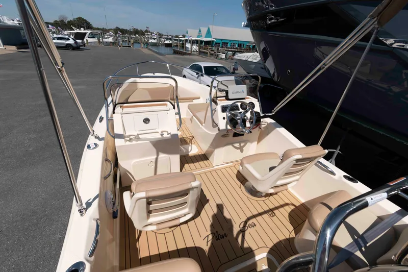 Slide: The Image of 2023 Scout 175 Sportfish boat interior with beige seating and modern dashboard. - 4