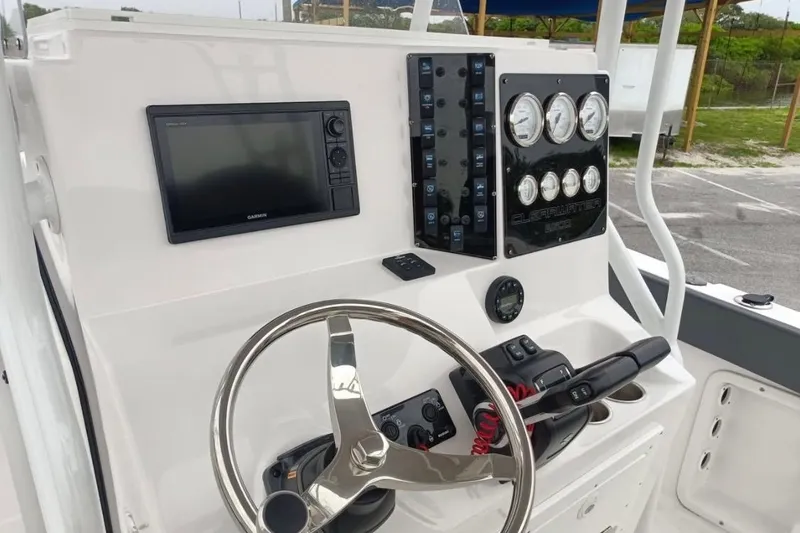 Slide: The Image of 2024 Clearwater 2500 boat dashboard with steering wheel, gauges, and navigation system. - 4