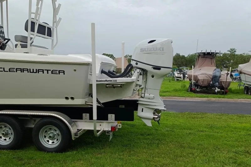 Slide: The Image of 2024 Clearwater 2500 boat with Suzuki outboard motor on a trailer, parked on grass. - 6