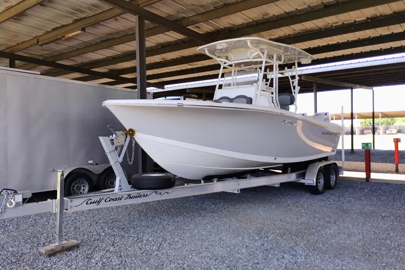 The Image of 2024 Clearwater 2500 Center Console boat on trailer in covered storage area. - 0