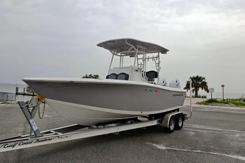 The Image of 2024 Clearwater 2500 boat on trailer by waterfront, overcast sky. - 1