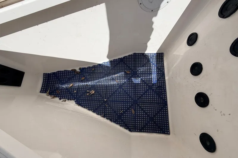 Slide: The Image of Interior of a 2006 Regulator 29 Forward Seating boat with blue mat and scattered debris. - 11