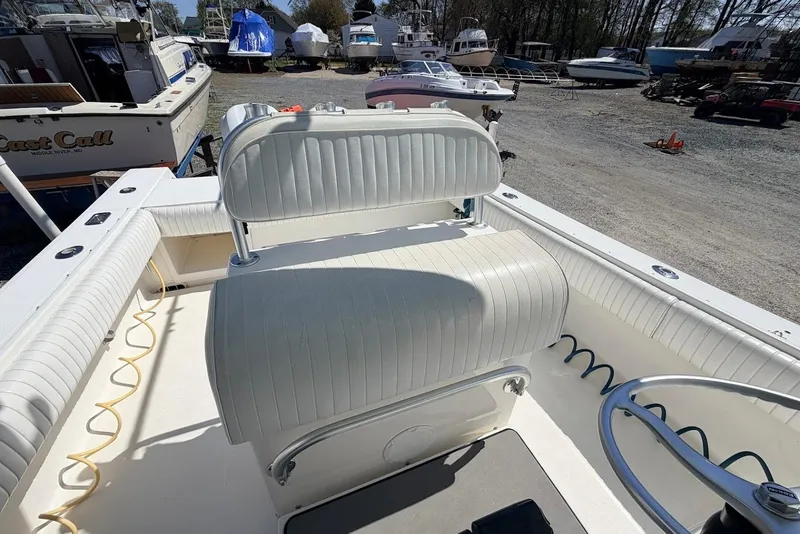 Slide: The Image of 2006 Regulator 29 Forward Seating boat interior with white cushioned seats and steering wheel. - 13