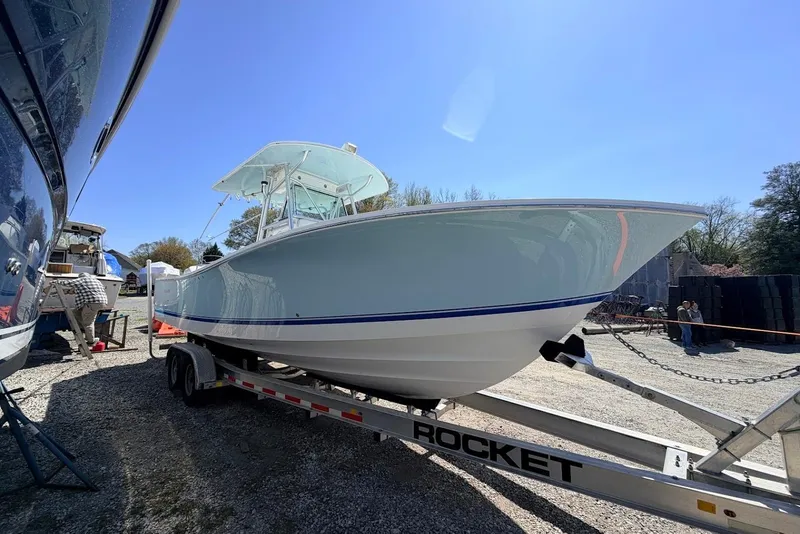Slide: The Image of 2006 Regulator 29 Forward Seating boat on trailer under clear blue sky. - 18