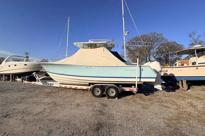 Slide: The Image of 2006 Regulator 29 Forward Seating boat on trailer, covered, parked outdoors. - 21