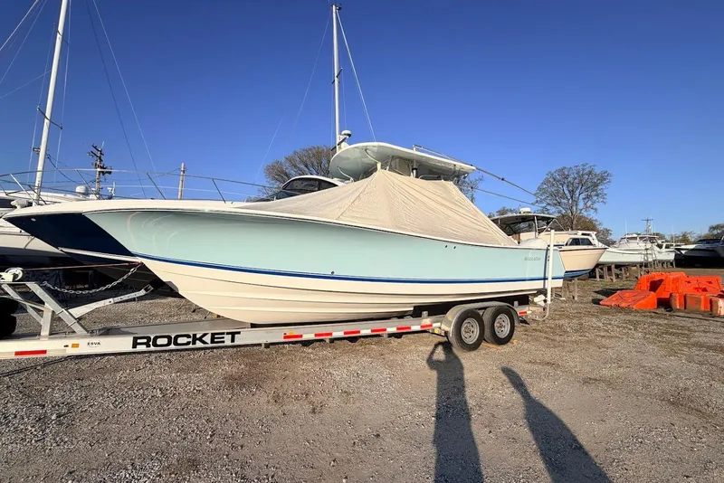 Slide: The Image of 2006 Regulator 29 Forward Seating boat on trailer, covered, in a boatyard. - 22