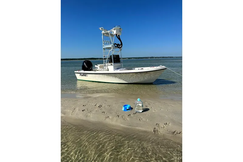 The Image of Parker 1801 Center Console boat anchored on sandy beach, clear blue sky. - 0