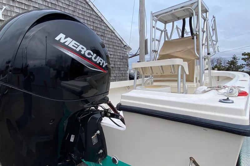 Slide: The Image of 2000 Parker 1801 Center Console boat with Mercury engine, docked near a wooden building. - 3