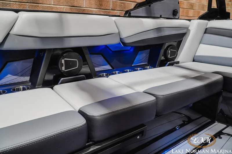 Slide: The Image of 2026 Axis A245 boat interior with sleek seating, cup holders, and ambient blue lighting. - 22
