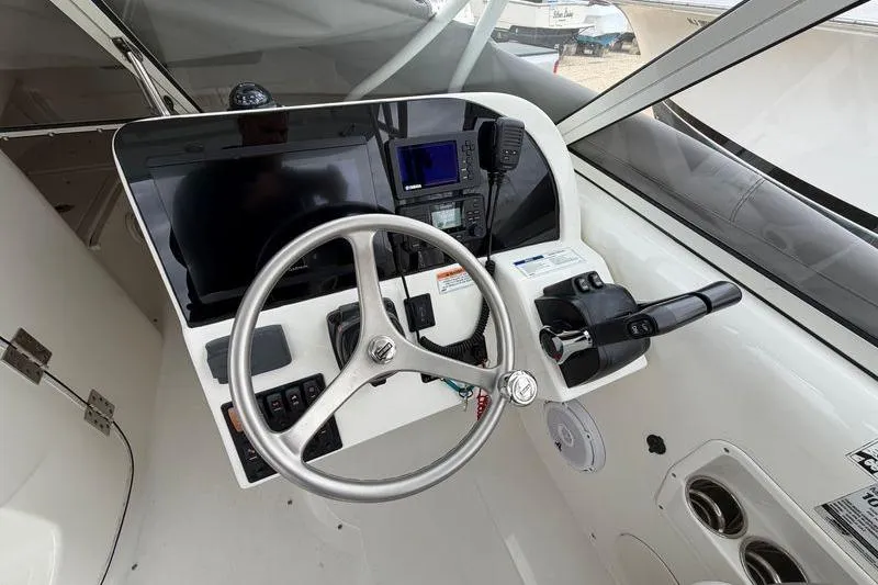 Slide: The Image of Cockpit of 2019 World Cat 255 DC boat with steering wheel and navigation controls. - 10