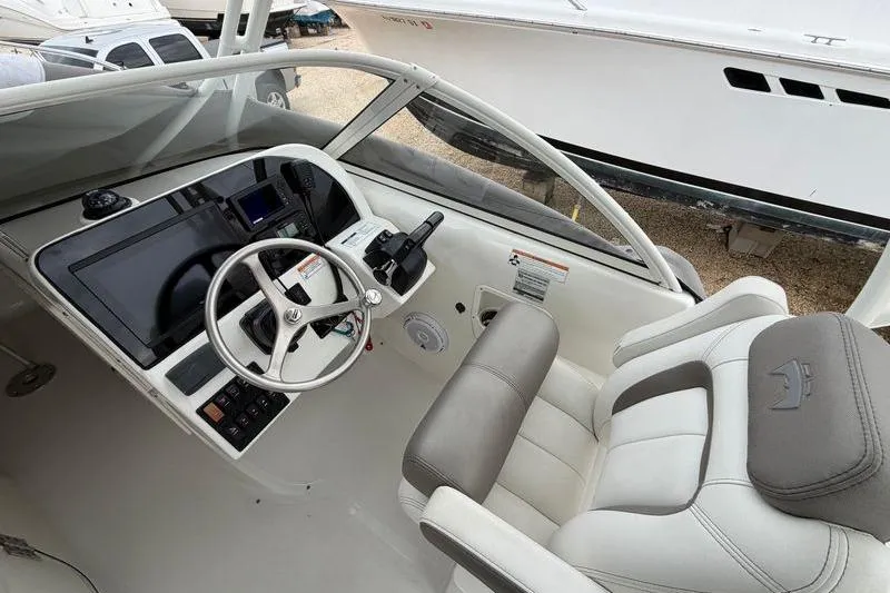 Slide: The Image of 2019 World Cat 255 DC boat cockpit with steering wheel and control panel. - 11