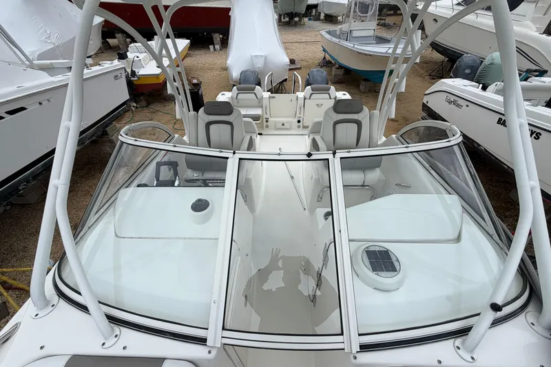 Slide: The Image of 2019 World Cat 255 DC boat with dual consoles and seating, docked among other boats. - 12