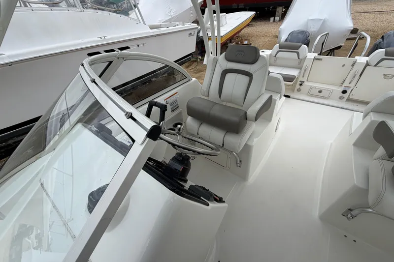 Slide: The Image of 2019 World Cat 255 DC boat interior with steering wheel and seating. - 15