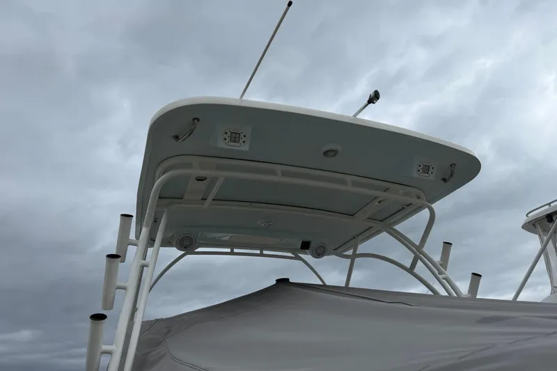 Slide: The Image of 2019 World Cat 255 DC boat with a covered top against a cloudy sky. - 21