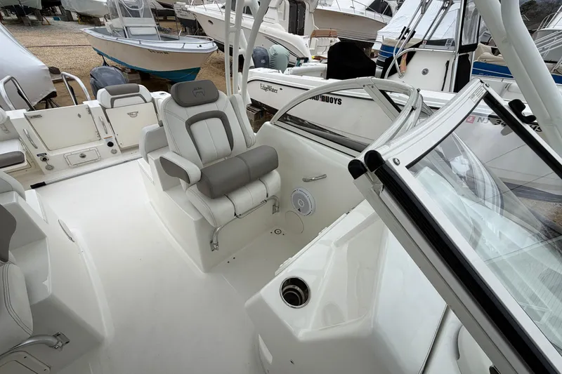 Slide: The Image of 2019 World Cat 255 DC boat with a covered top against a cloudy sky. - 24