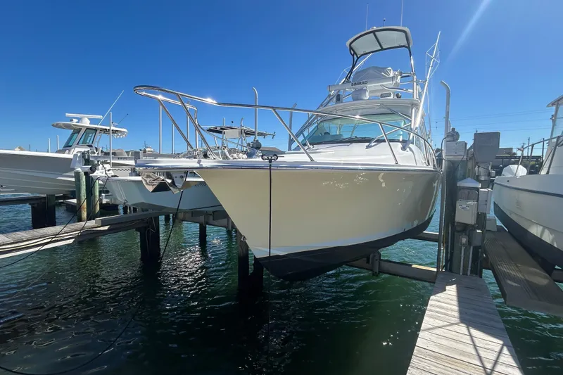 Slide: The Image of 2018 Albemarle 29 Express boat docked at marina under clear blue sky. - 2