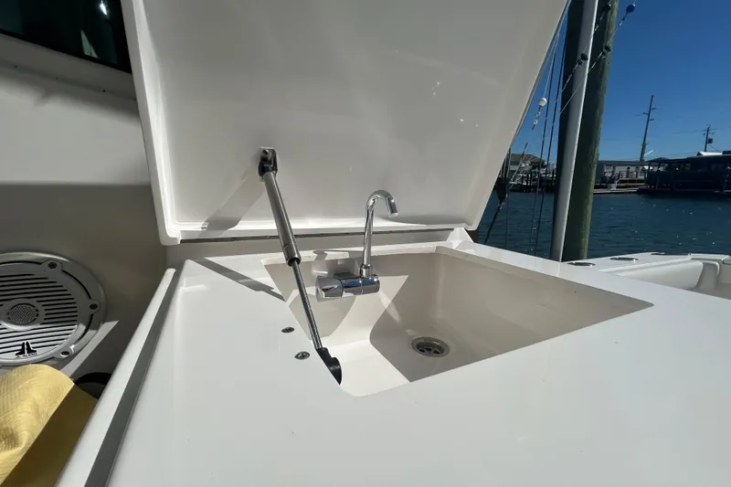 Slide: The Image of 2018 Albemarle 29 Express boat sink with open lid, dockside view. - 23