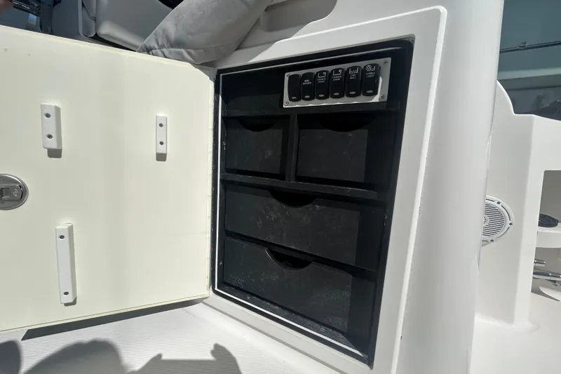 Slide: The Image of Open storage compartment on a 2018 Albemarle 29 Express boat with control panel. - 24