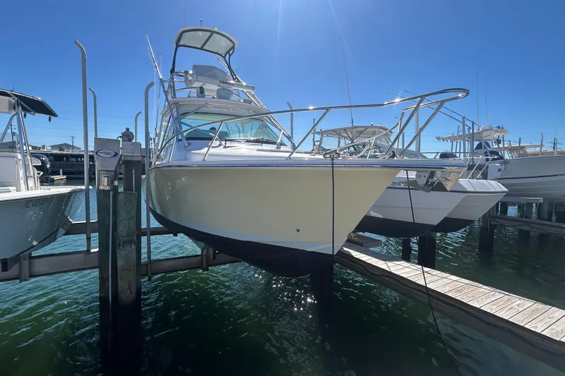Slide: The Image of 2018 Albemarle 29 Express boat docked at marina under clear blue sky. - 3