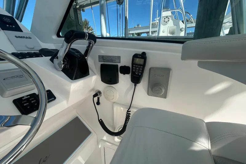 Slide: The Image of 2018 Albemarle 29 Express helm with steering wheel, controls, and communication equipment. - 34