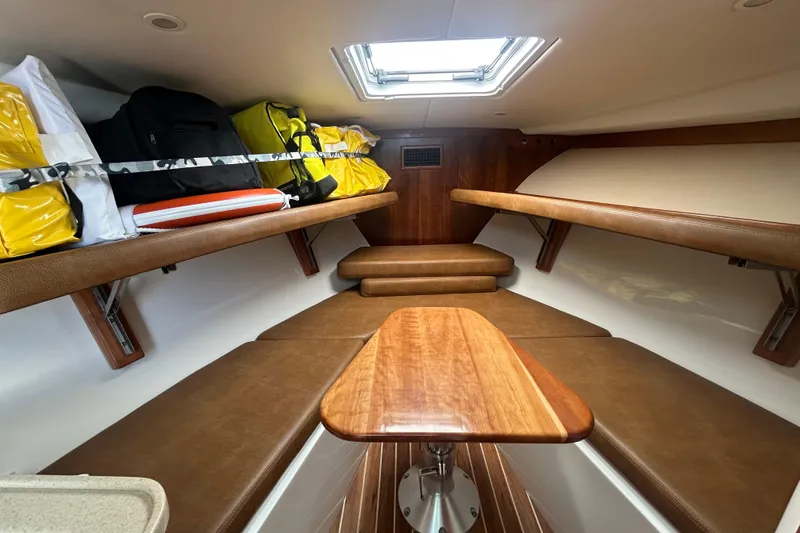 Slide: The Image of 2018 Albemarle 29 Express cabin interior with storage, seating, and wooden table. - 48