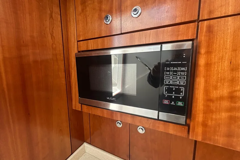 Slide: The Image of Built-in microwave in 2018 Albemarle 29 Express boat's wooden cabinetry. - 53