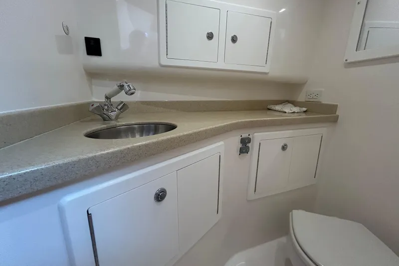 Slide: The Image of 2018 Albemarle 29 Express boat bathroom with sink, countertop, and storage cabinets. - 59