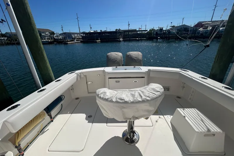 Slide: The Image of 2018 Albemarle 29 Express boat cockpit with covered seating, docked by the water. - 8