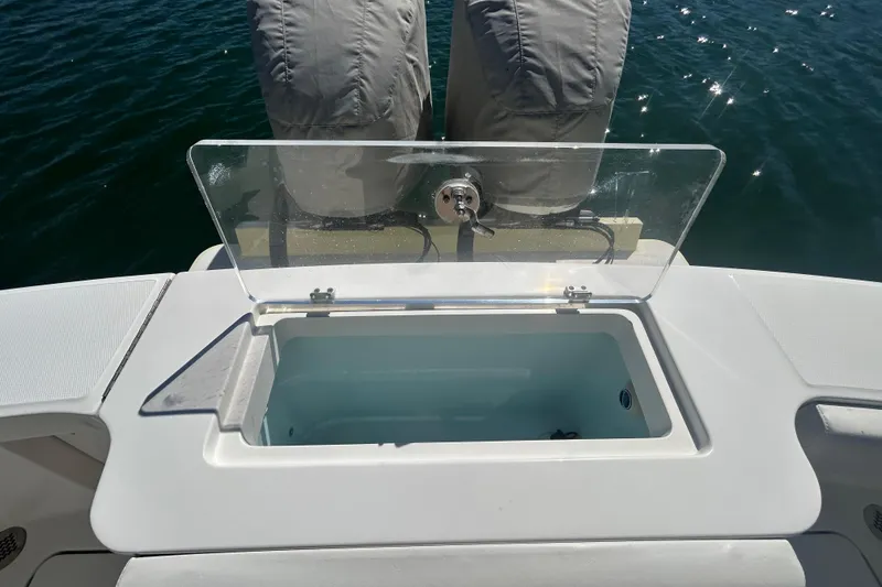 Slide: The Image of 2018 Albemarle 29 Express boat with open storage compartment, covered engines, and water backdrop. - 9