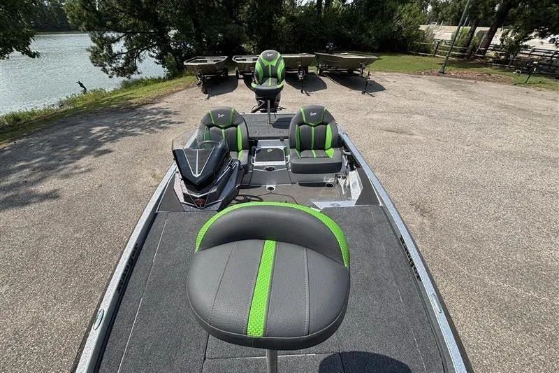 Slide: The Image of 2026 Ranger Z519R Cup-Equipped boat with green-accented seats, parked near a lake. - 22