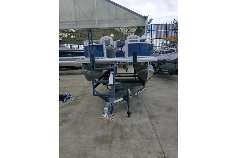 Slide: The Image of 2026 Sun Tracker Bass Buggy 16 XL Select pontoon boat on trailer in outdoor setting. - 4