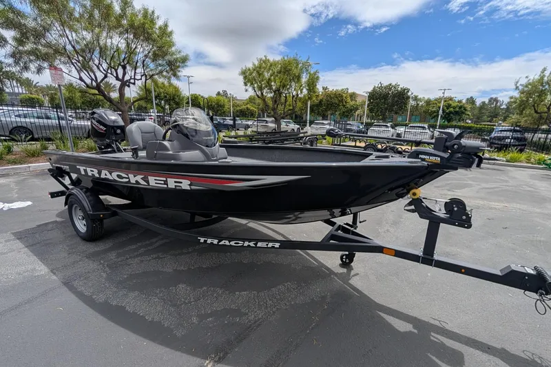 The Image of 2026 Tracker Super Guide V-16 SC boat on trailer in parking lot. - 0