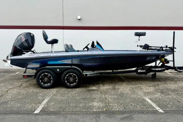 The Image of 2026 Triton 20XP Patriot bass boat with dual axle trailer, parked outdoors. - 0