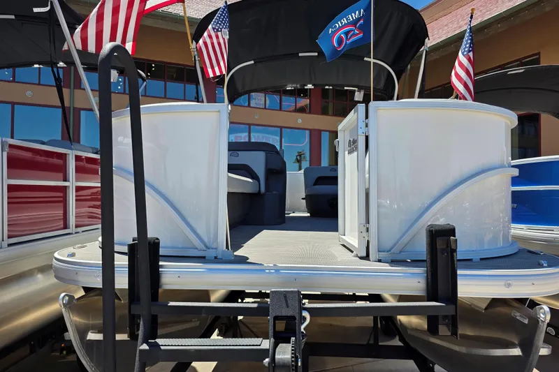 Slide: The Image of 2026 Sun Tracker Party Barge 18 DLX pontoon boat with American flags displayed. - 1