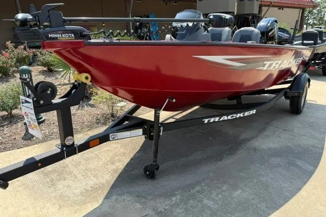 Slide: The Image of 2026 Tracker Super Guide V-16 SC boat on trailer, red exterior, parked outdoors. - 2