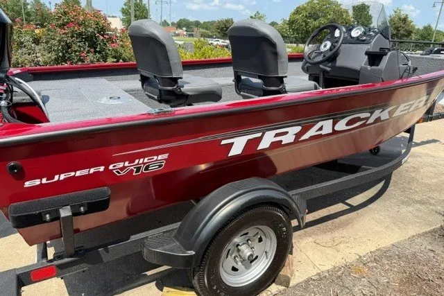 The Image of 2026 Tracker Super Guide V-16 SC boat, red exterior, parked on trailer, sunny day. - 0