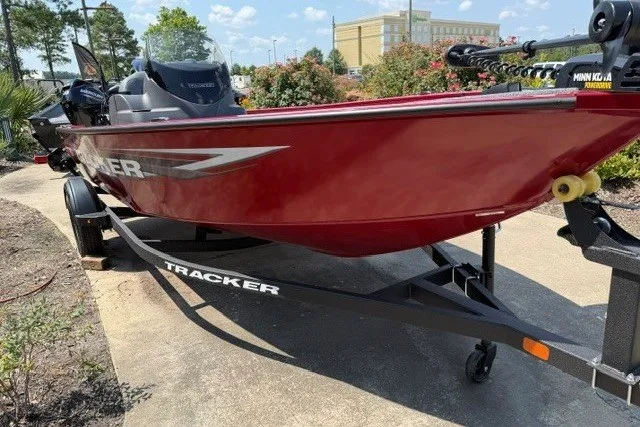 Slide: The Image of 2026 Tracker Super Guide V-16 SC boat on trailer, red exterior, parked outdoors. - 3
