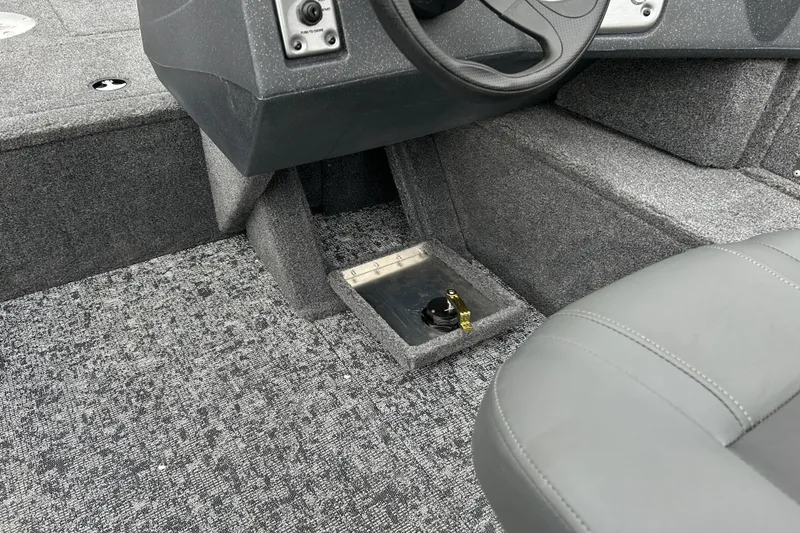 Slide: The Image of Interior of 2026 Tracker Pro Guide V-16 SC boat, featuring steering wheel and carpeted flooring. - 25