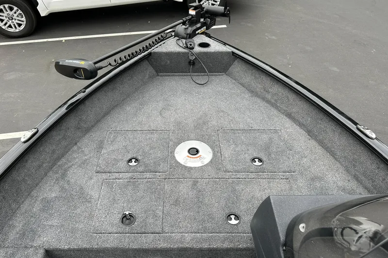 Slide: The Image of The image shows the bow deck of a Tracker Pro Guide V-16 SC boat with gray carpeting. - 21