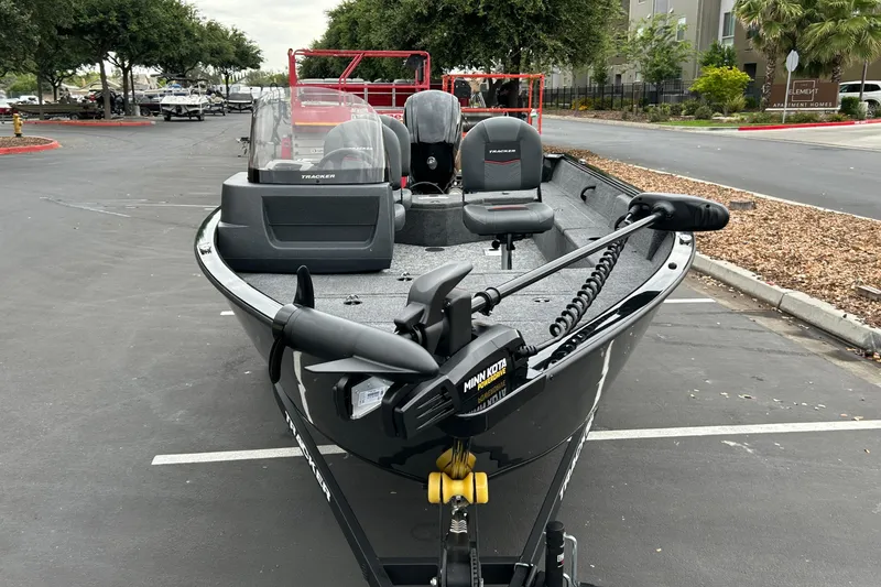 Slide: The Image of 2026 Tracker Pro Guide V-16 SC boat parked in a lot, featuring Minn Kota trolling motor. - 4