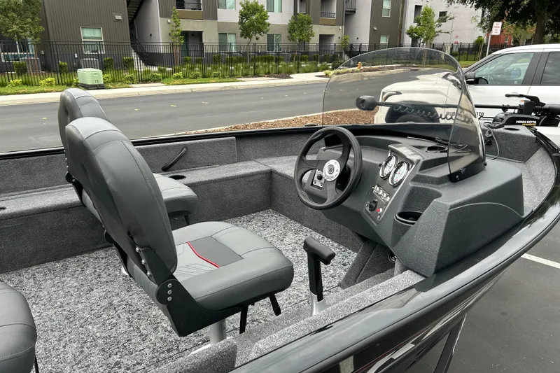 Slide: The Image of 2026 Tracker Pro Guide V-16 SC boat interior with steering console and seating. - 5