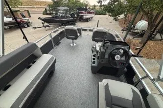 Slide: The Image of 2026 Sun Tracker Bass Buggy 16 XL Select pontoon boat interior with seating and steering console. - 15