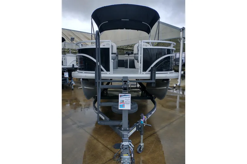 Slide: The Image of 2026 Sun Tracker Fishin' Barge 20 DLX pontoon boat on trailer, outdoor display. - 4