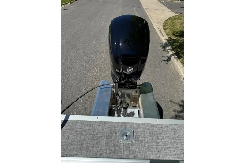 Slide: The Image of 2026 Sun Tracker Party Barge 20 DLX with outboard motor on a paved road. - 18