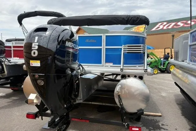 Slide: The Image of 2026 Sun Tracker Party Barge 22 DLX with Mercury 150 engine, displayed outdoors. - 2