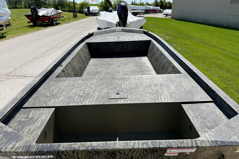 Slide: The Image of 2026 Tracker Grizzly 1648 Utility boat with camouflage design, parked outdoors. - 2